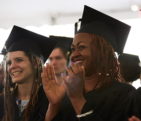 Microcollege students clapping at graduation.