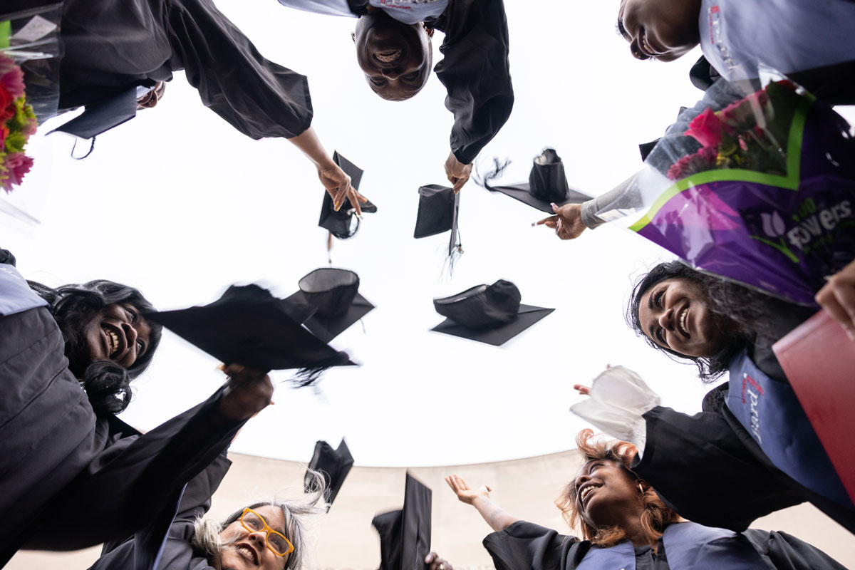 Students throwing their graduation caps in the air.