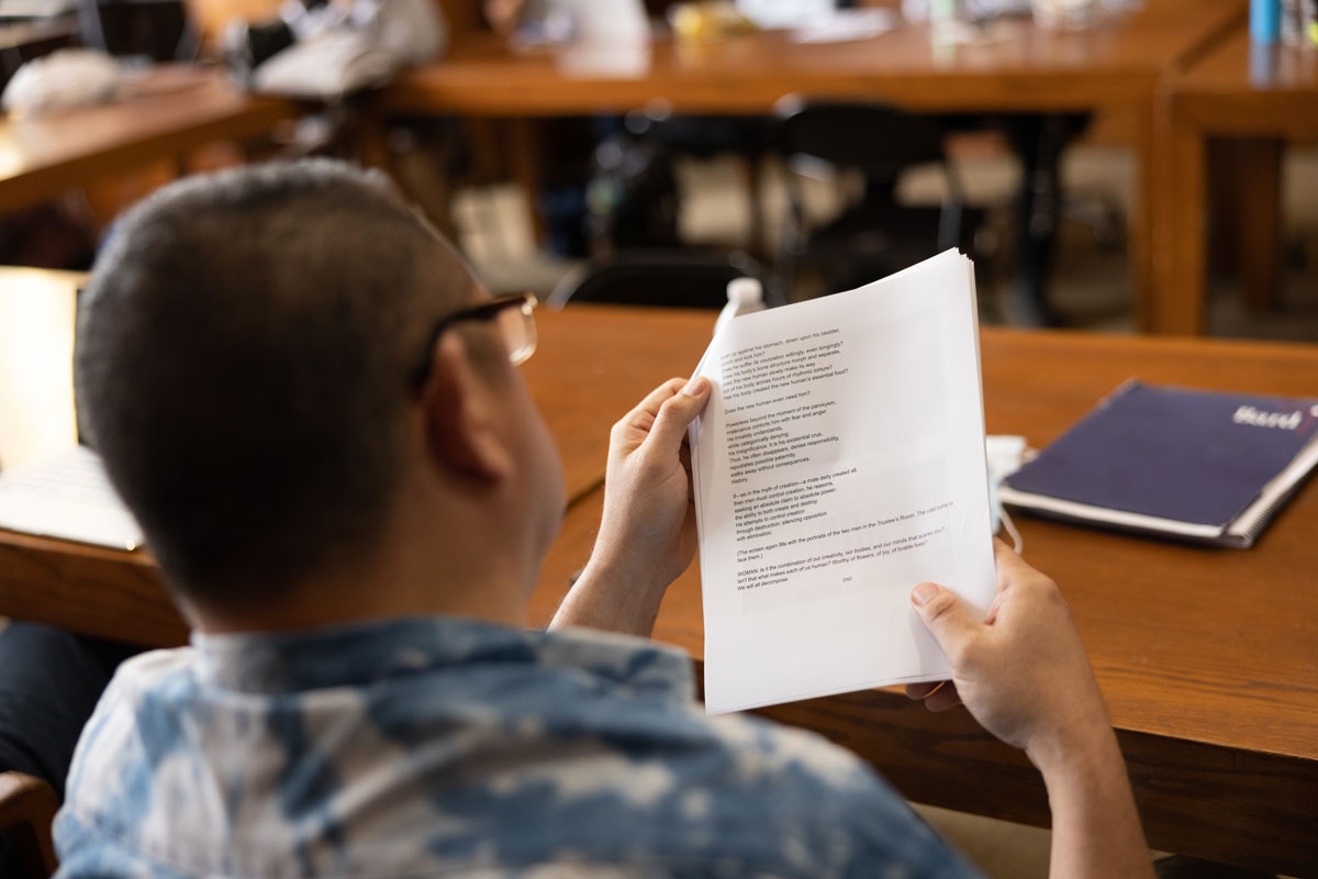 Student reading from a printed packet.