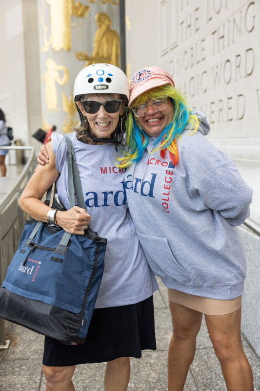 Students in microcollege gear smiling on the steps of the Brooklyn Public Library.