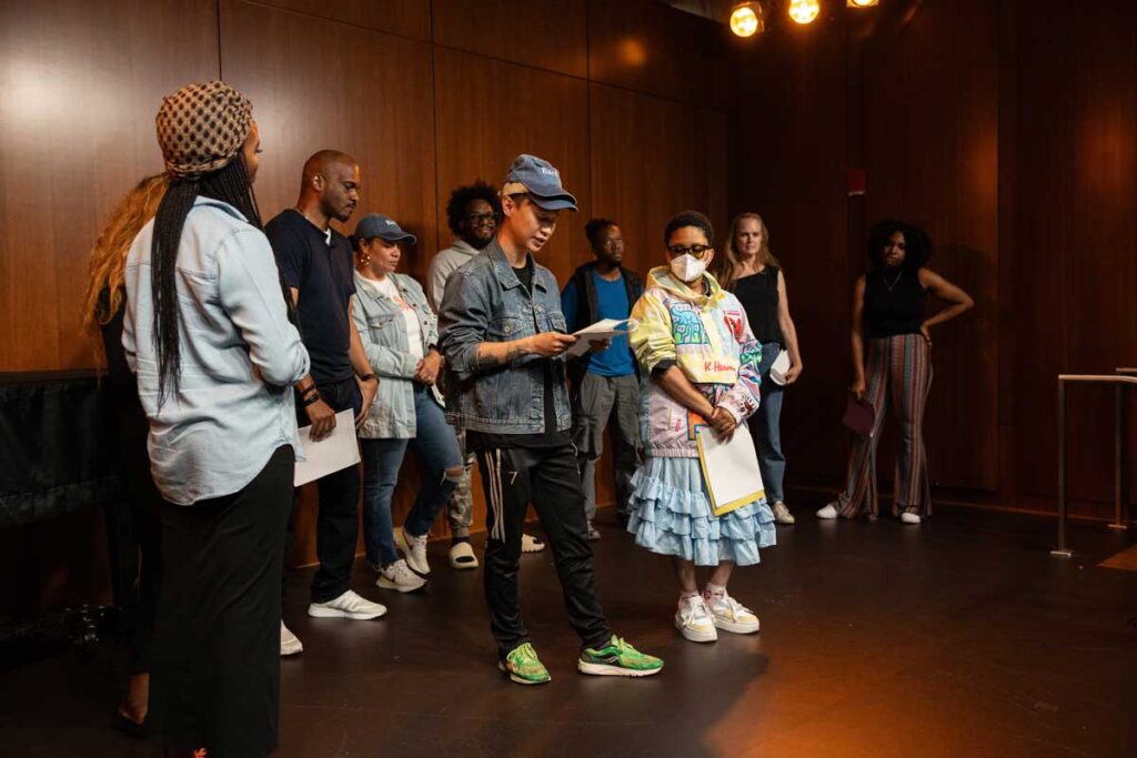 Students at Brooklyn Public Library presenting in an auditorium.